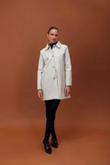 Trench de cuero ovino, de largo midi, con cuello clásico, cierre frontal de botones y diseño de líneas limpias.