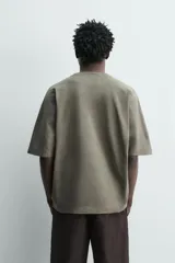 Camiseta boxy fit color verde militar con efecto lavado, confeccionada en tejido compacto de algodón con cuello redondo y manga corta.