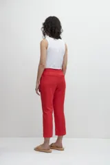 Pantalón capri de lino color rojo, con bolsillos laterales y cierre con botón a presión.