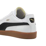 Championes Puma 9T blancos con detalles en verde y beige, suela color caramelo.
