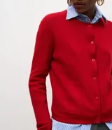Cardigan de punto color celeste, con mangas largas, cierre frontal de botones y dos bolsillos delanteros. Presenta acabado canelado en el escote y los puños.