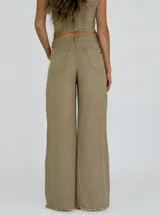 Pantalón de tiro alto color ladrillo, de corte palazzo con aberturas laterales en el ruedo y terminación desflecada.