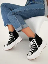 Championes tipo botita de caña alta con diseño bicolor, cuerpo en color negro y suela de plataforma gruesa en color blanco con base de goma.