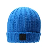 Gorro tejido de punto acanalado en color azul, con vuelta en el borde y parche rectangular negro con logo grabado en el frente.