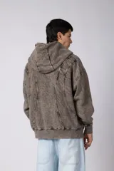 Campera oversize con capucha y cierre frontal, confeccionada en tela con acabado acid wash que le otorga un aspecto desgastado. Presenta costuras curvas decorativas en el frente y la espalda, puños y ruedo acanalados, y un calce relajado.