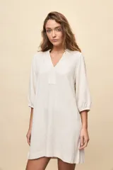 Vestido corto negro de silueta relajada, con escote en V y mangas 3/4 levemente abullonadas.