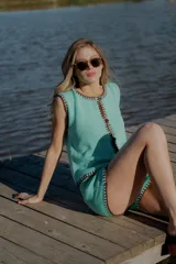 Conjunto tejido de algodón color celeste con terminaciones en marrón. Incluye un top sin mangas con botones y un short de tiro alto.