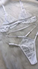 Conjunto de lencería compuesto por un bralette de encaje con breteles regulables y una tanga colaless regulable con diseño de doble tira a la cintura.