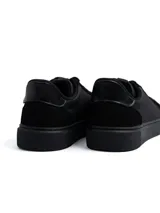 Championes urbanos Marruecos de color negro, confeccionados en ecocuero con detalles de paneles en ecogamuza en los laterales, pas cordones y talón. Poseen suela de goma al tono.