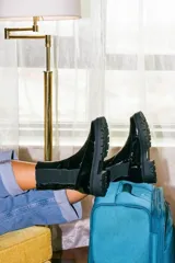 Bota tipo chelsea de cuero acharolado negro, con elásticos laterales y suela track dentada.