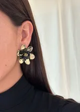 Aros dorados en forma de flor texturizada con doble vuelta de cristales entrelazados en el centro.