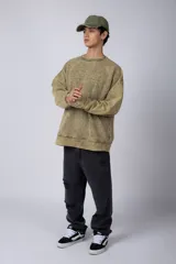 Buzo de cuello redondo con efecto de teñido artesanal acid wash. Presenta un corte oversize, mangas largas con puños acanalados y etiqueta pequeña en el puño izquierdo.