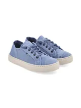 Zapatillas de lona color azul, con cordones al tono y suela de goma en color crema. Diseño de estilo casual con costuras reforzadas y etiqueta lateral pequeña.
