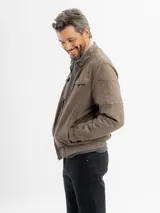 Campera de estilo casual confeccionada en tejido suave con textura tipo gamuza. Presenta cuello alto, cierre frontal, bolsillos laterales y bolsillos frontales con solapa. Incluye detalles de costuras en las mangas y terminaciones elastizadas en puños y cintura.