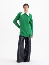 Sweater de punto color rojo con diseño de trenzas verticales y textura estructurada. Presenta cuello redondo, mangas largas y un corte holgado con terminaciones acanaladas.