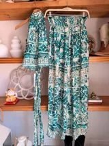 Conjunto de dos piezas color fucsia con estampado oriental en tonos rosa y blanco, compuesto por un top halter con lazo en la cintura y un pantalón palazzo de cintura alta con elástico.