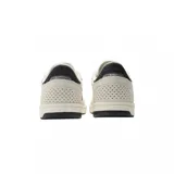 Championes urbanos New Balance modelo 440, de diseño bajo con combinación de colores blanco y crema. Presenta el logo 'N' en color negro en los laterales, refuerzos de gamuza en la puntera y talón, y perforaciones decorativas en la parte trasera.