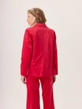 Blazer negro de simil terciopelo con cuello y puños en color marrón. Tiene bolsillos delanteros y forro estampado.