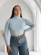 Polera celeste de tejido de punto acanalado, con cuello alto y corte crop.