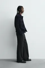 Cazadora de corte cropped confeccionada en tejido con acabado flocado efecto terciopelo. Presenta cuello solapa, cierre frontal con botones metálicos, bolsillos de plastrón con solapa en el pecho y mangas largas con puños abotonados.