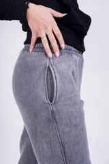 Pantalón de jogging gris con efecto lavado, corte holgado y logo bordado en negro.