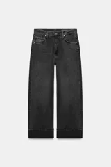 Jeans de tiro medio con corte baggy y pierna relajada. Presenta diseño de cinco bolsillos, cierre frontal con cremallera y botón, y bajo con vuelta marcada.
