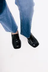 Mocasín de cuero con textura de reptil en color bordó, con punta cuadrada y taco bloque bajo de color negro.