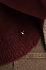 Sweater de tejido de punto con diseño de bloques de color en tonos beige, blanco roto y bordó. Presenta cuello redondo y mangas largas.