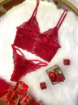 Conjunto de lencería compuesto por un bralette de encaje con diseño floral y una tanga a juego con tiras laterales ajustables. El bralette cuenta con breteles regulables y una banda inferior de satén.