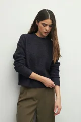 Sweater de punto con textura en relieve, cuello redondo y mangas largas con puños ajustados.