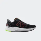 Championes de running New Balance modelo 880v13, color negro con detalles en rojo y verde neón. Presentan entresuela Fresh Foam X para mayor amortiguación y suela de goma NDurance para mayor durabilidad. Confeccionados con parte superior de malla técnica.