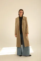 Tapado largo de paño en color beige, con solapas clásicas, cierre frontal de botones y corte recto estructurado.