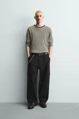Pantalón cargo de corte relajado confeccionado en tejido de algodón con elasticidad. Presenta bolsillos laterales tipo cargo con solapa en las perneras, bolsillos frontales y bolsillos traseros de doble vivo. Cierre frontal con cremallera y botón.