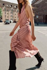 Vestido midi de satén con cuello halter y escote drapeado. Presenta un diseño a rayas diagonales y detalle de volantes en el frente.