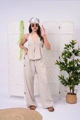 Pantalón palazzo de lino color beige, de tiro medio-alto, con cintura elastizada y silueta holgada de caída fluida.