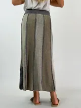 Pollera larga de punto con rayas verticales en tonos de azul y gris.