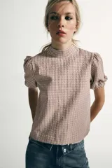 Camisa de manga corta con estampado de cuadros vichy, cuello subido y detalle de abertura en la espalda con lazada del mismo tejido.