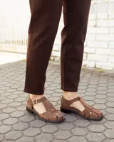 Sandalias de cuero gamuzado color marrón, tipo romanas, con tiras entrelazadas, talón cerrado y tira ajustable con hebilla metálica en el tobillo.