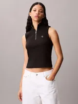 Musculosa Calvin Klein de corte slim, confeccionada en punto de canalé fino. Presenta cuello perkins con cierre frontal parcial y etiqueta tejida con el logo monograma en el pecho.
