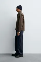 Sobrecamisa de corte regular fit confeccionada en tejido de algodón con acabado lavado. Presenta cuello solapa, cierre frontal de botones, mangas largas con puños abotonados y un bolsillo plastrón en el pecho.
