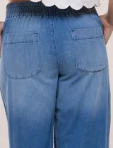 Jean pull on de tiro alto, color azul oscuro, con perneras amplias estilo wide leg, cintura elastizada en la espalda y bolsillos delanteros tipo parche con pespuntes contrastantes.