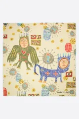 Chal de lana con estampado artístico de figuras fantásticas, rostros y elementos geométricos sobre fondo color crema. Presenta bordes desflecados y el logo de la marca estampado en una esquina.