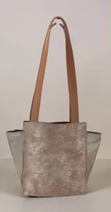 Cartera de cuero de la marca Carolina De Cunto, modelo Nia de la línea Ottenta Basic. Presenta diseño combinado en tonos marrón y tostado con detalles en pelo natural con estampado animal print, bolsillos con cierre exterior e interior, porta llaves y doble asa de hombro.