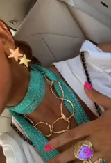 Corbatín turquesa tejido con hilo brillante, con collar de eslabones dorados.