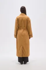 Trinchera larga de corte holgado, con cuello solapa, cierre frontal con botones y cinturón ajustable a la cintura. Cuenta con mangas largas y bolsillos laterales.