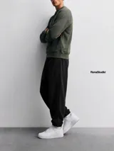 Pantalón jogger de algodón color negro, con corte relajado, cintura elástica con cordón ajustable y puños elásticos en los tobillos.