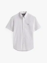Camisa de hombre de manga corta, color blanco, confeccionada en puro algodón Oxford. Presenta cuello con botones y el logo de Tommy Hilfiger bordado en el pecho.