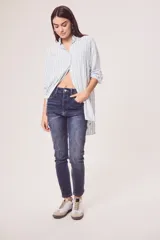Camisa oversize celeste y blanca a rayas verticales, de mangas largas con puños abotonados y cuello camisero.