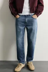 Jeans de corte slim cropped confeccionados en denim de algodón rígido con efecto lavado. Presentan tiro medio, cierre frontal con cremallera y botón, y diseño clásico de cinco bolsillos.
