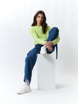 Sweater tramado color verde lima, de manga larga y cuello redondo.